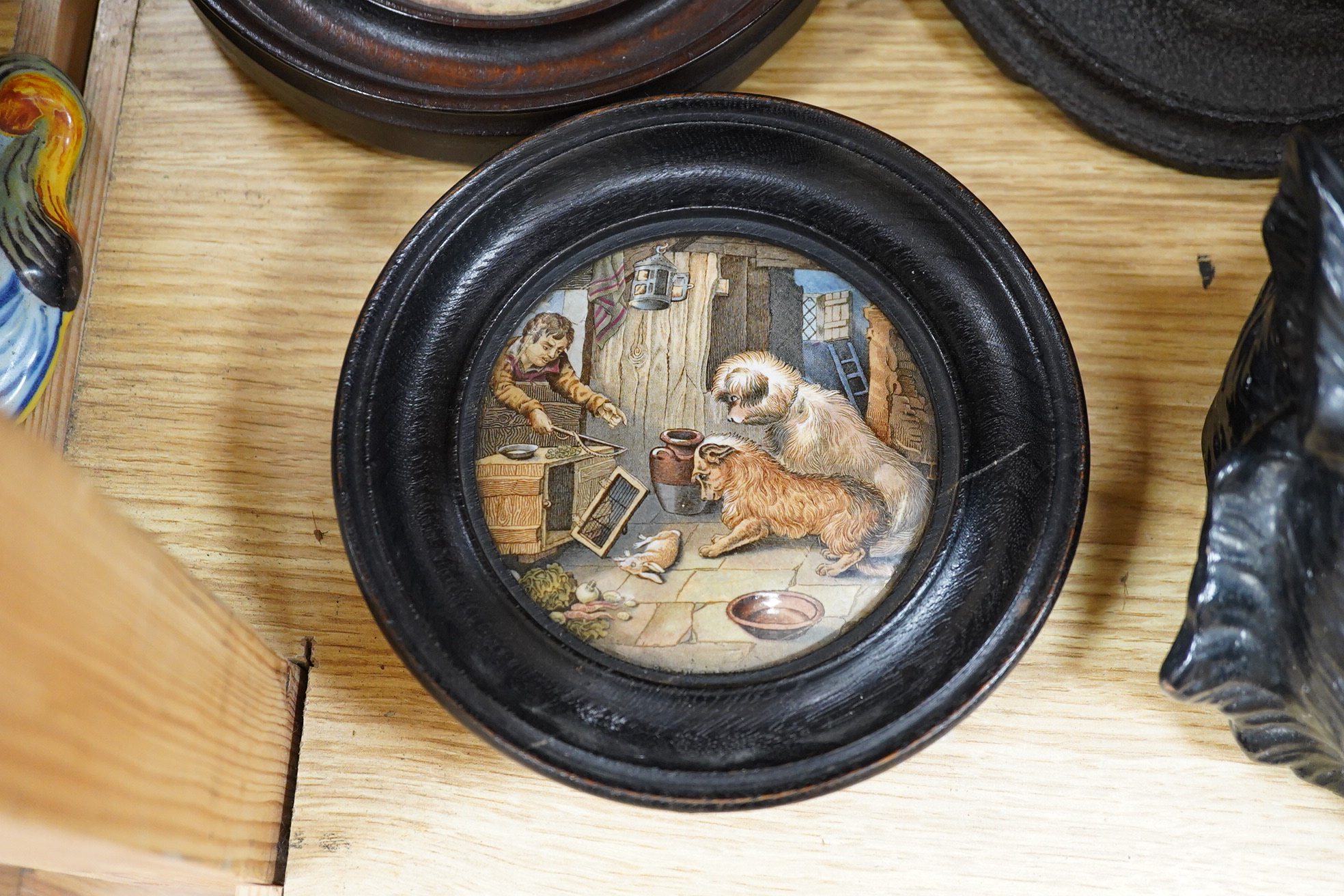 Two framed pot lids, two oval figural plaques,a moustache cup and saucer, two Bretby cats, framed print and mixed nut crackers cutlery etc